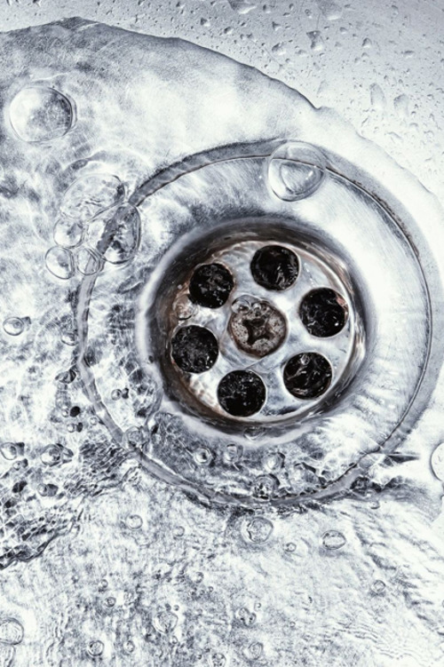 closeup of water going down a drain