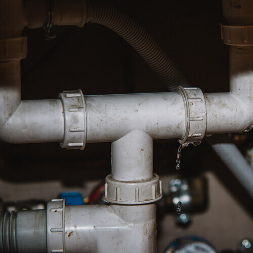 closeup of leaking PVC pipes